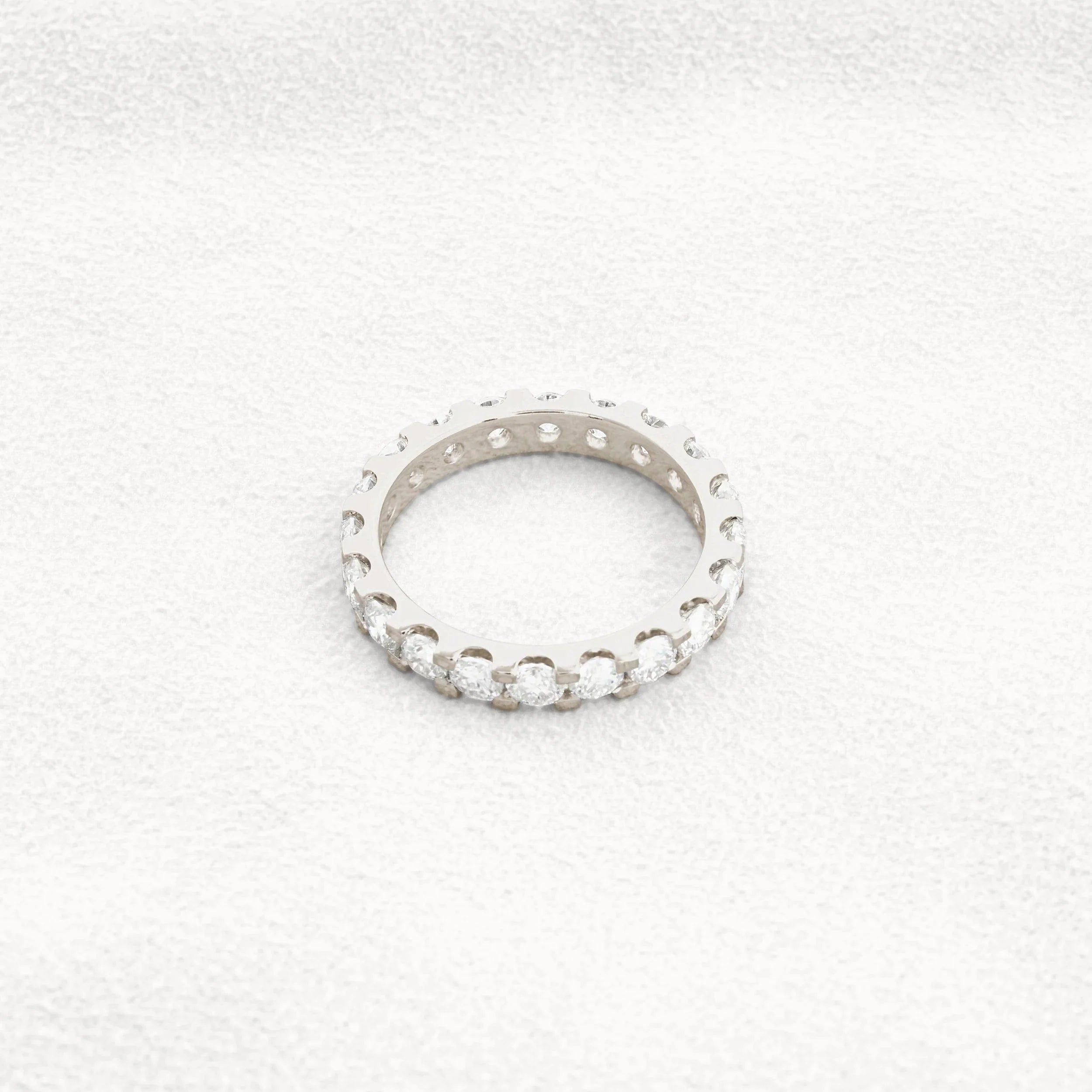 14k gold round lab grown diamond eternity band, top angle view showing fine craftsmanship with brilliant sparkle